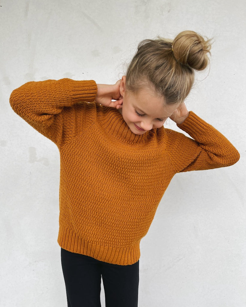 Pige iført orange Alfreds Trøje Junior 
