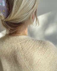 Detaljebillede af kvinde iført hvid Champagne Cardigan