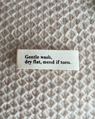 "Gentle wash, dry flat, mend if torn."-label