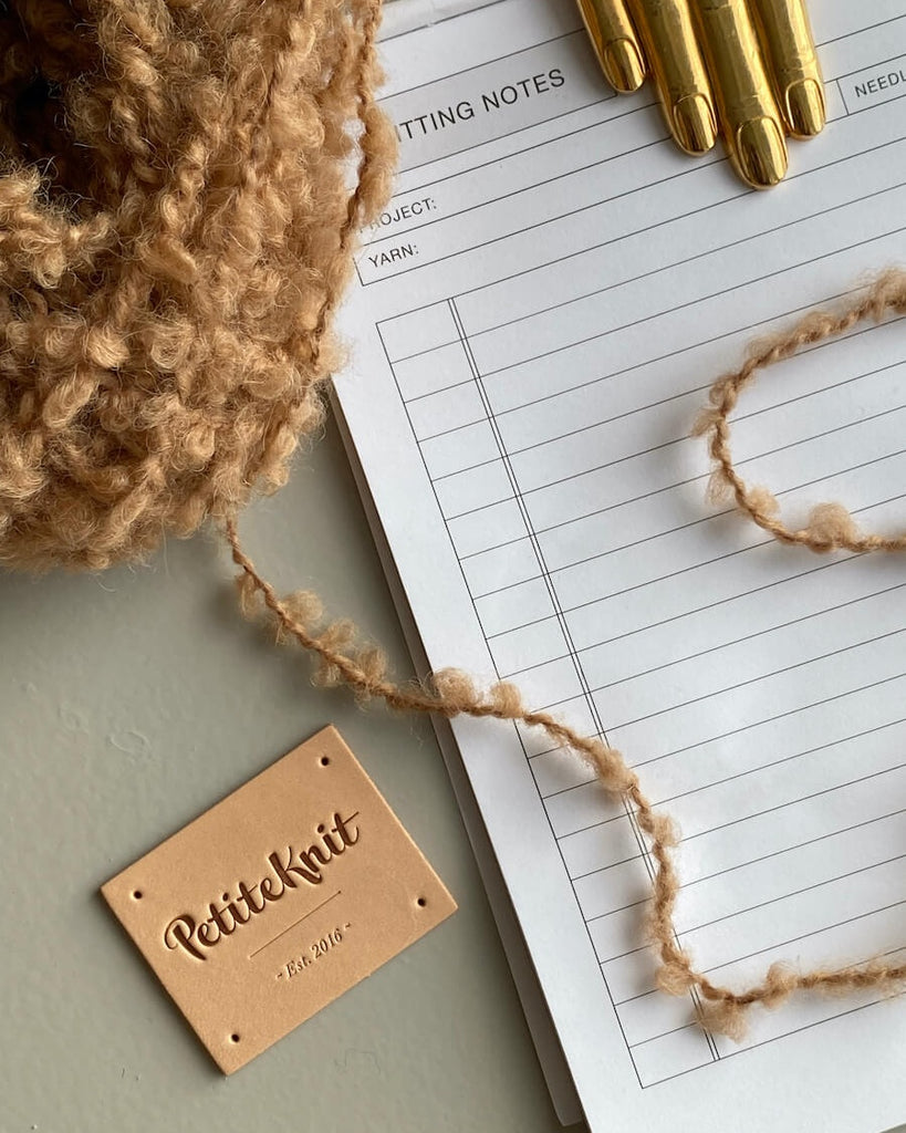 Læderlabel med Petiteknit logo på bord