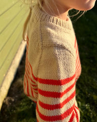 Barn iført hvid og rød Lyon Sweater Junior 