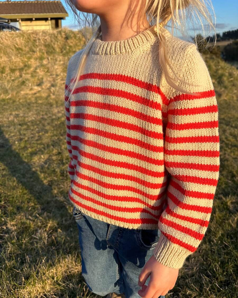Barn iført hvid og rød Lyon Sweater Junior 