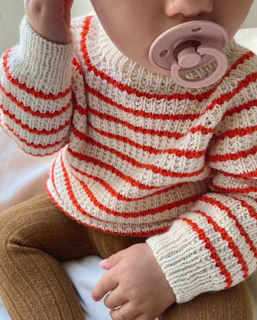 Barn iført Friday Sweater Baby med røde striber