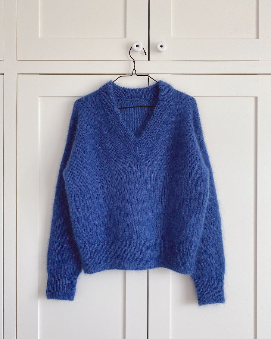 Kvinde iført rød Stockholm Sweater V-neck